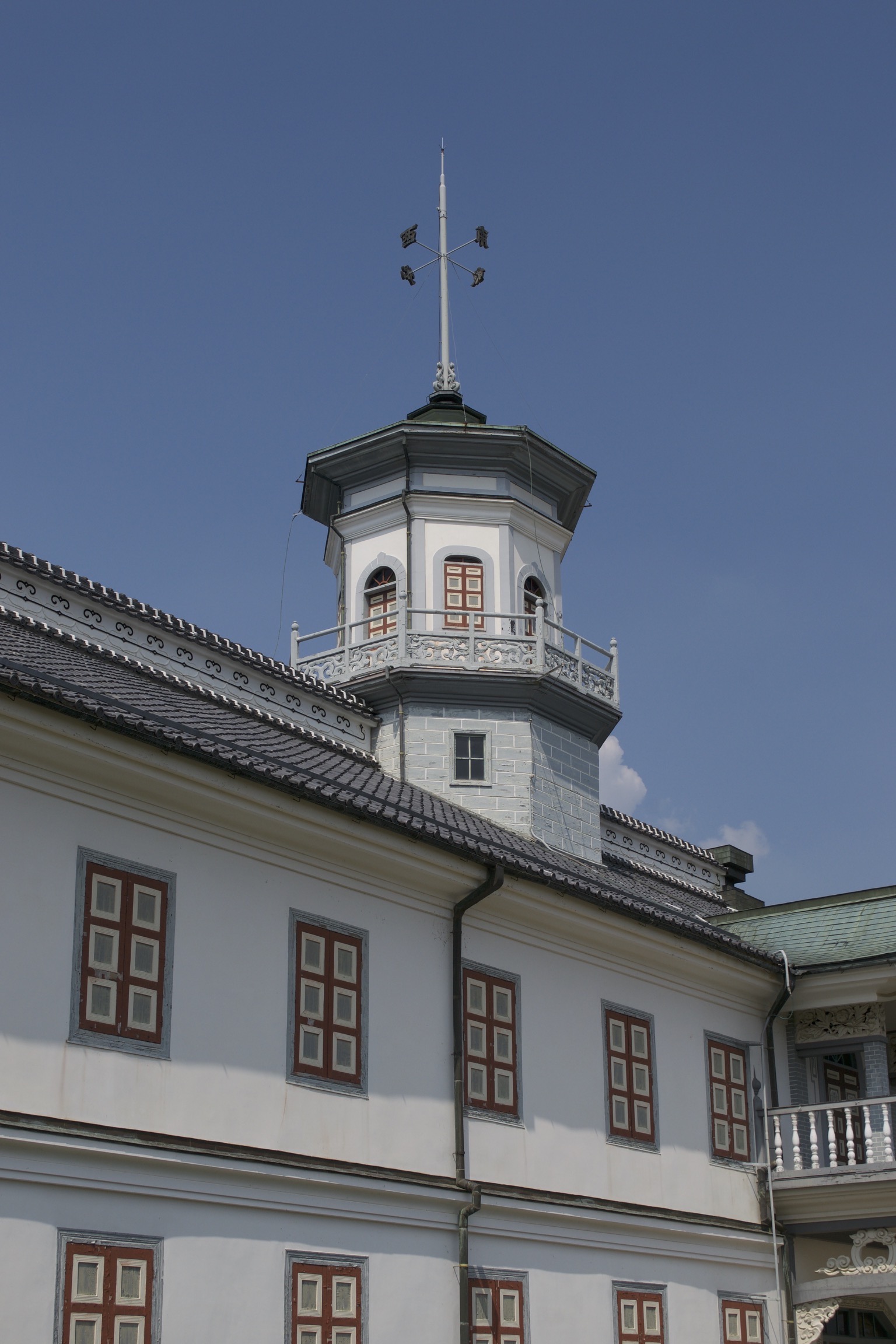 An octagonal tower atop a low, wide western-style building with Japanese elements.